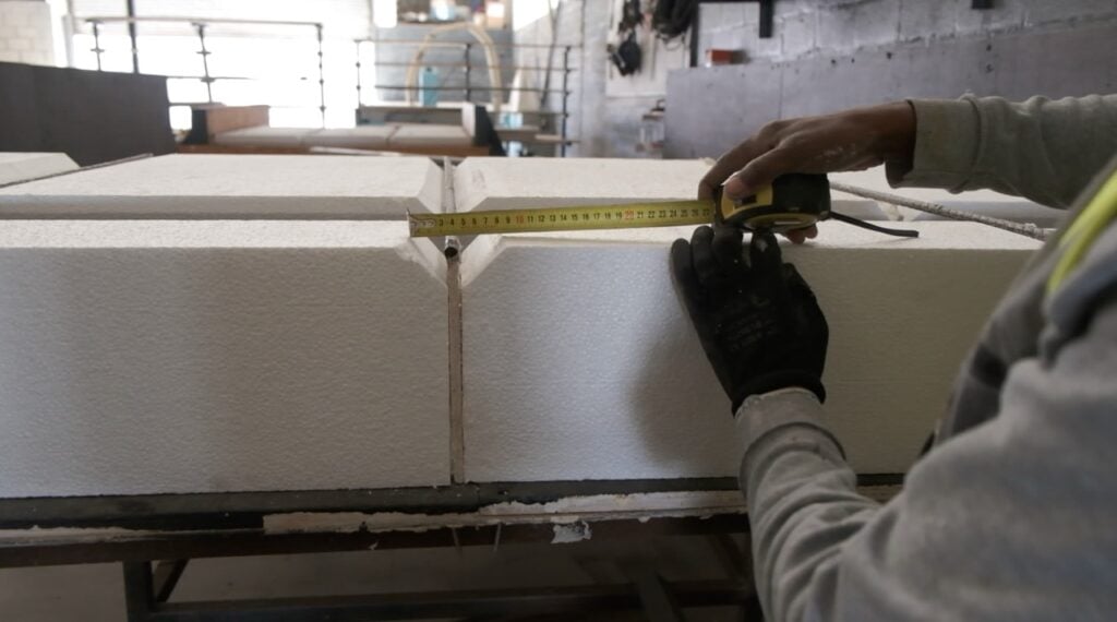 Citra workers measuring large foam blocks for construction or insulation purposes.