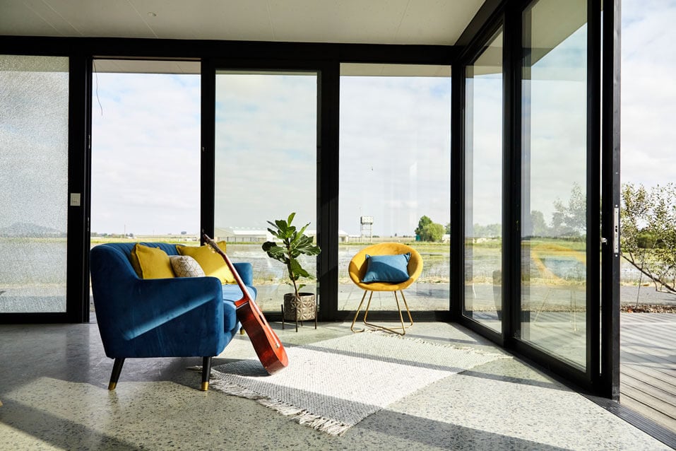 Bright living room with expansive glass walls and contemporary decor.