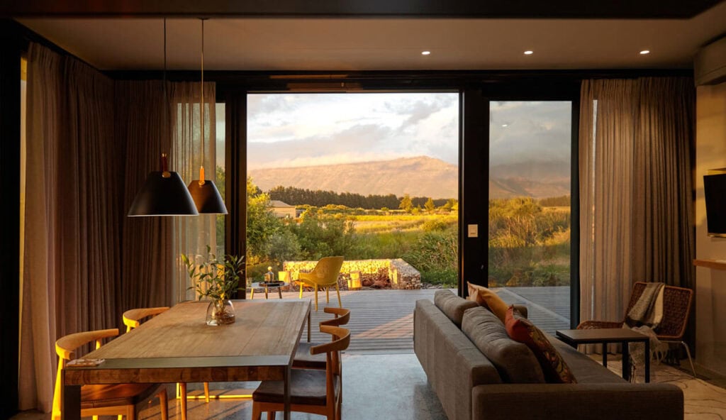 Bright living room with large glass doors showcasing scenic outdoor landscape.