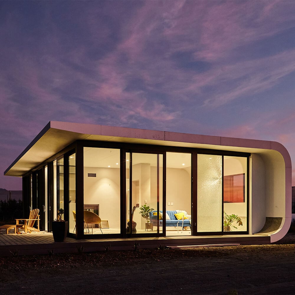 Modern minimalist house with curved architecture and expansive glass windows at dusk, showcasing con.