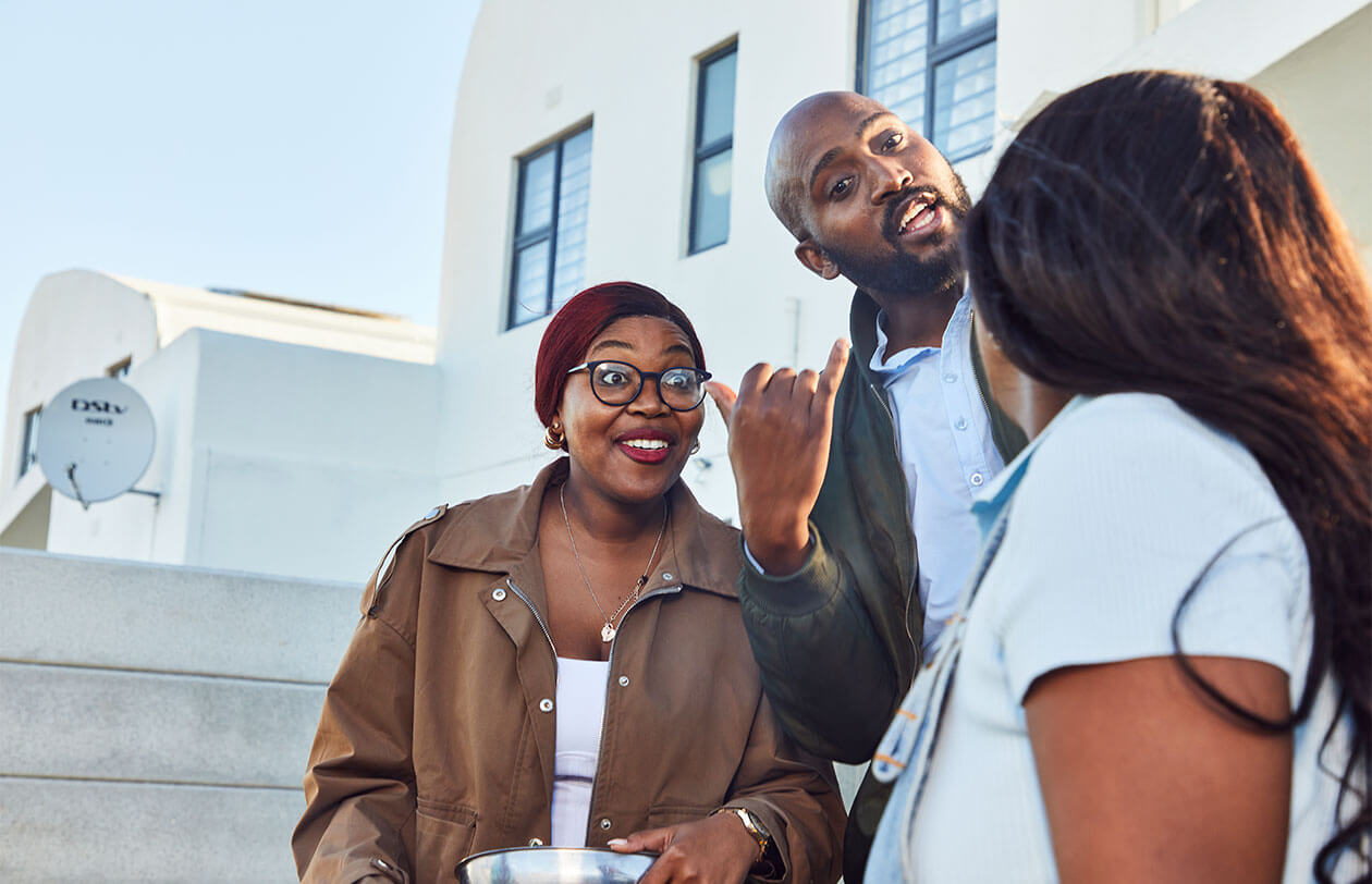 Social Impact Diverse group of professionals engaging in a discussion outdoors in front of a modern building.