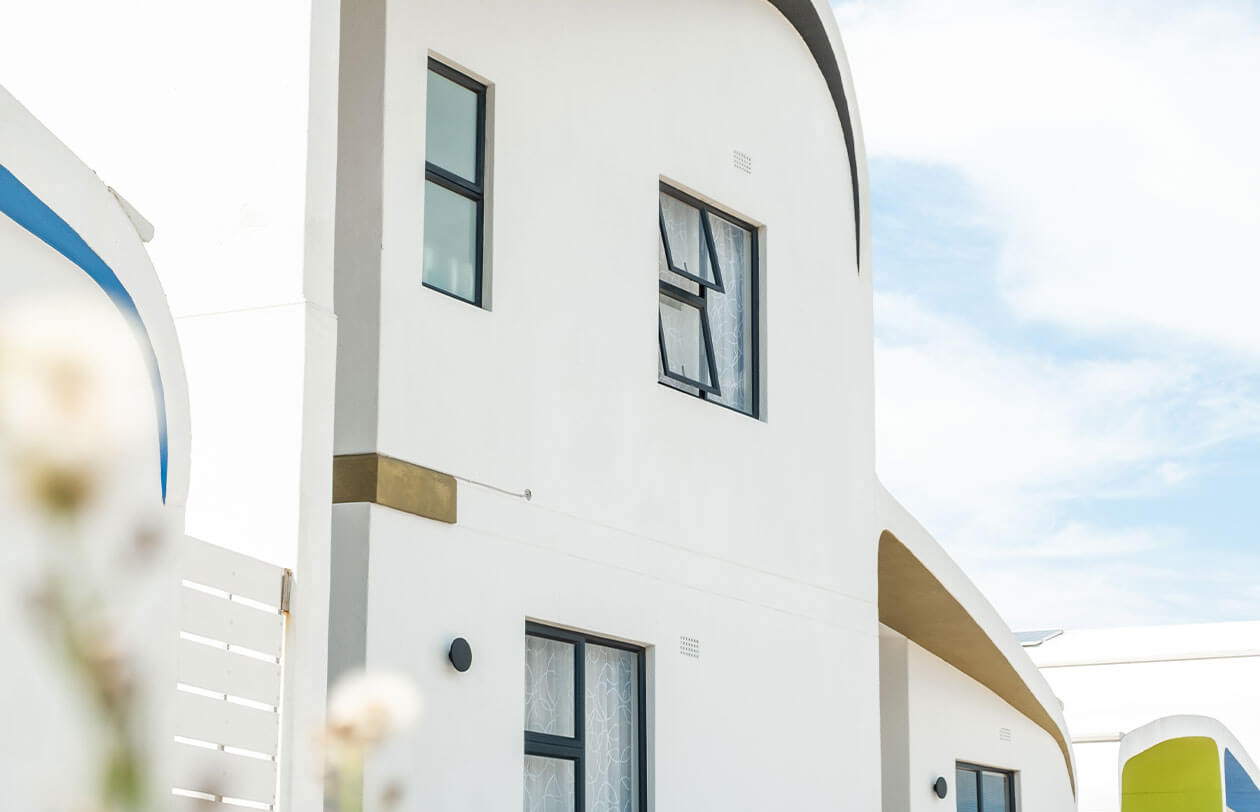 Sustainability Modern white building with curved architecture and large windows in Citra development.