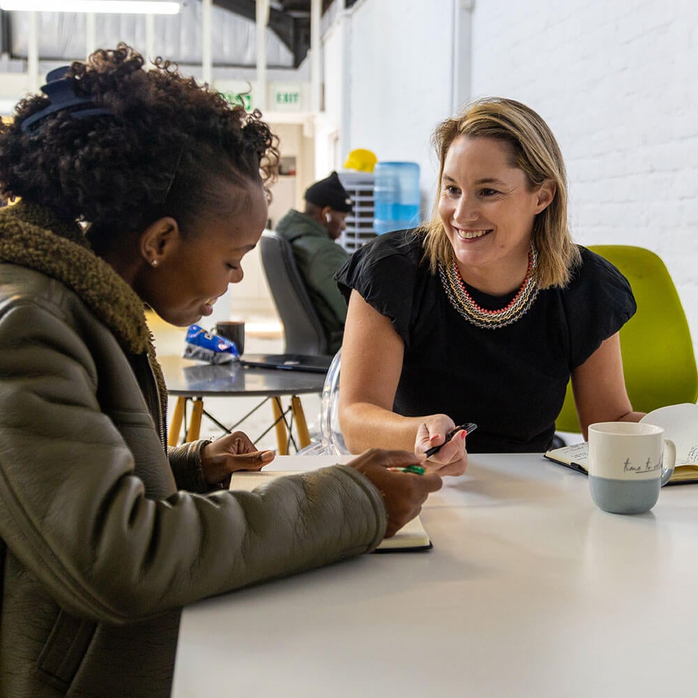 Two women collaborating at Citra workspace, discussing ideas.