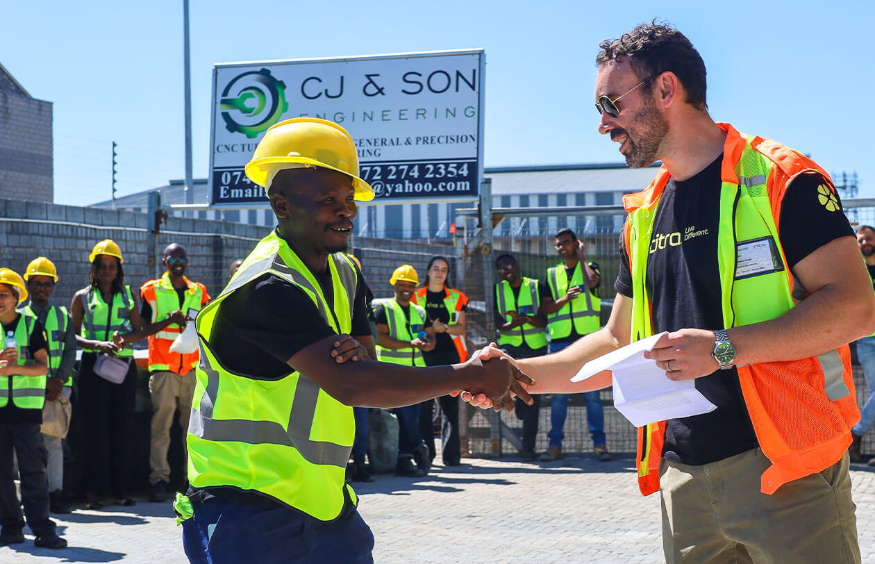 The Meaning Behind Citra Construction workers shaking hands at a site, team collaboration, safety gear, and professional envi.