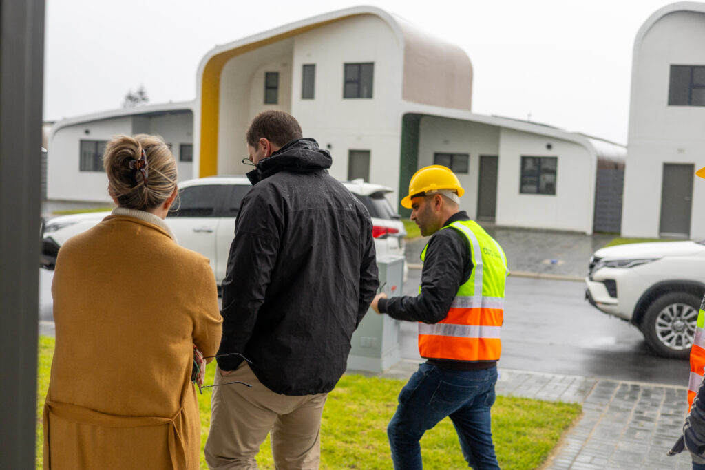 Mayor Geordin Hill-Lewis at CentralBlue walking with Citra CEO Joel Baur and the Head of Development, with a Citra eHome in the background.